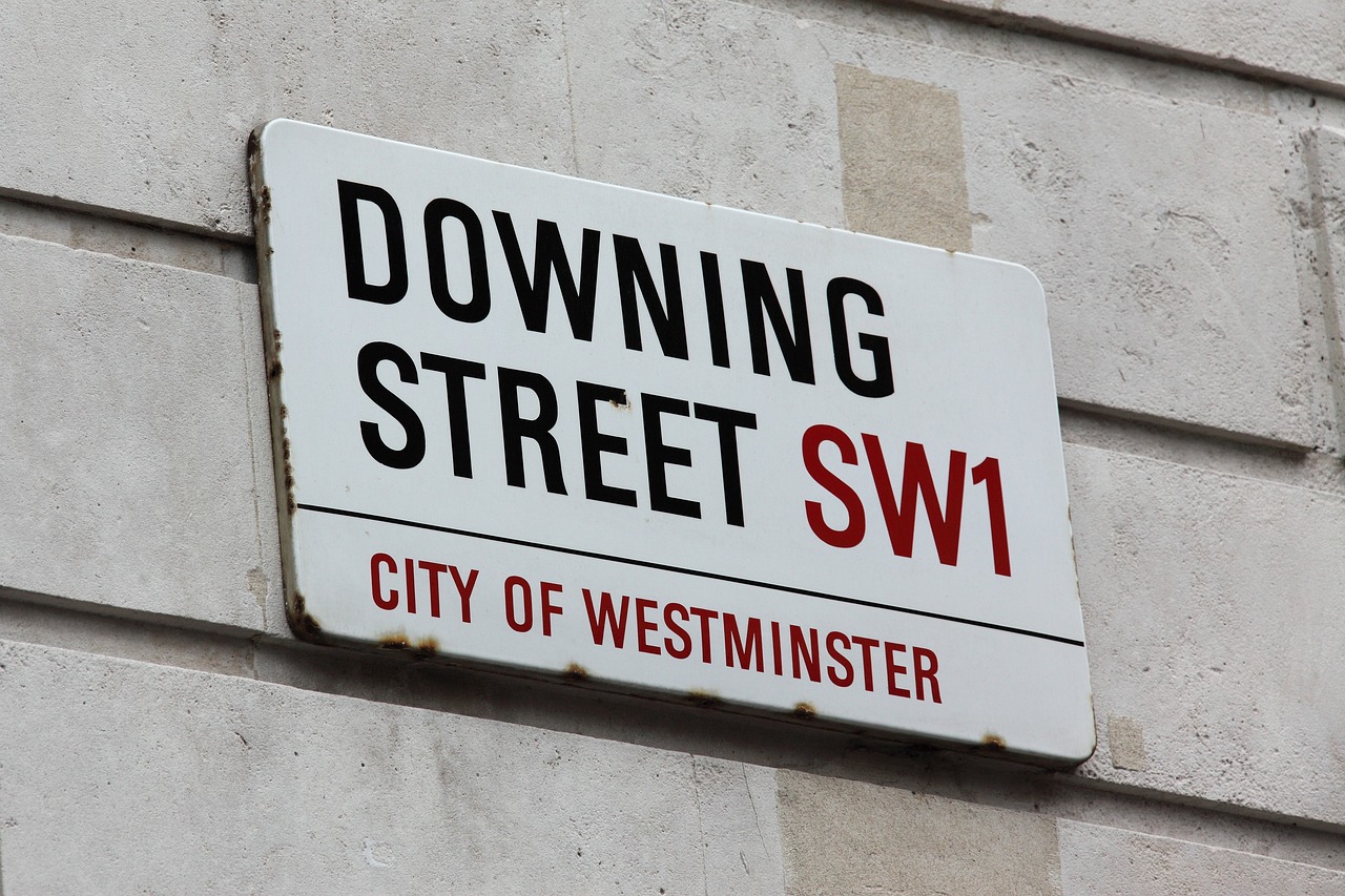 Street sign on wall, reads "Downing Street SW1, City of Westminster".