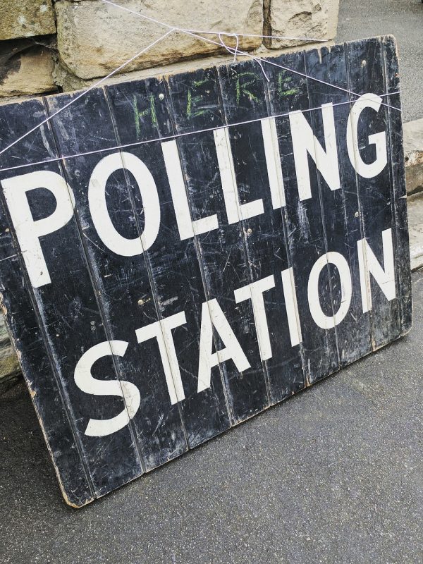 Black board painted with white letting stating "Polling Station".