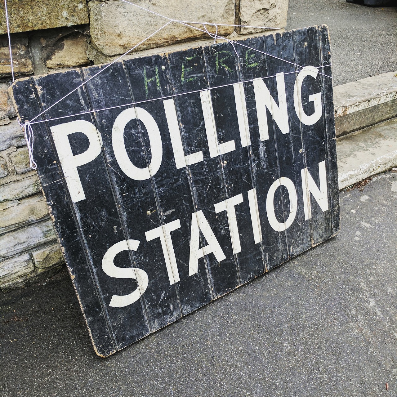 Black board painted with white letting stating "Polling Station".